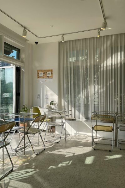 Sunlit modern café with minimalist design featuring chairs and tables.